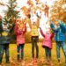Fall foliage covering European family playing in autumn landscape