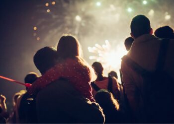 British families enjoying Bonfire Night fireworks display with children watching sparklers and bonfires during traditional Guy Fawkes celebration in UK