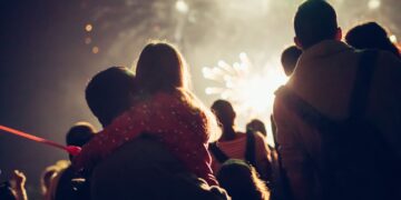 British families enjoying Bonfire Night fireworks display with children watching sparklers and bonfires during traditional Guy Fawkes celebration in UK