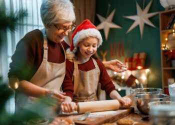 Making Gluten-Free Cookies for Christmas by grandmother and young girl with christmas hat