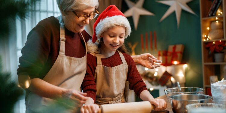 Making Gluten-Free Cookies for Christmas by grandmother and young girl with christmas hat