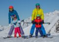 Skiers family enjoying early snow season conditions at European Alps resort destination