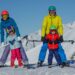 Skiërsfamilie geniet van vroege sneeuwseizoenomstandigheden in een Europees Alpenresort