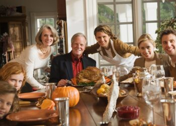 Thanksgiving expat families gather around festive dinner table with traditional turkey
