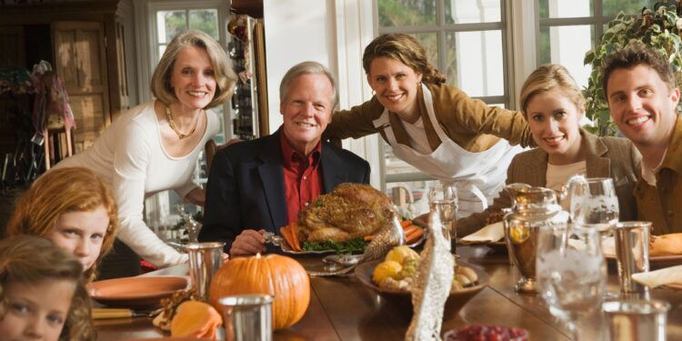 Thanksgiving expat families gather around festive dinner table with traditional turkey