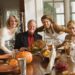 Expat-Familien versammeln sich zu Thanksgiving um den festlich gedeckten Tisch mit traditionellem Truthahn