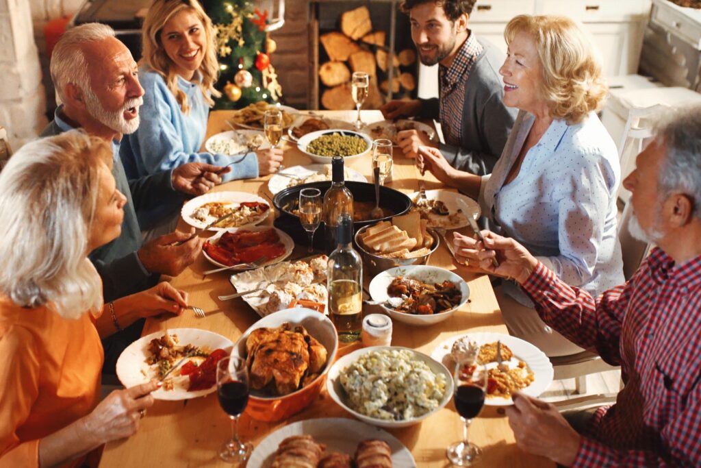 Thanksgiving expat families gather around festive dinner table with traditional turkey and European wine in modern European apartment