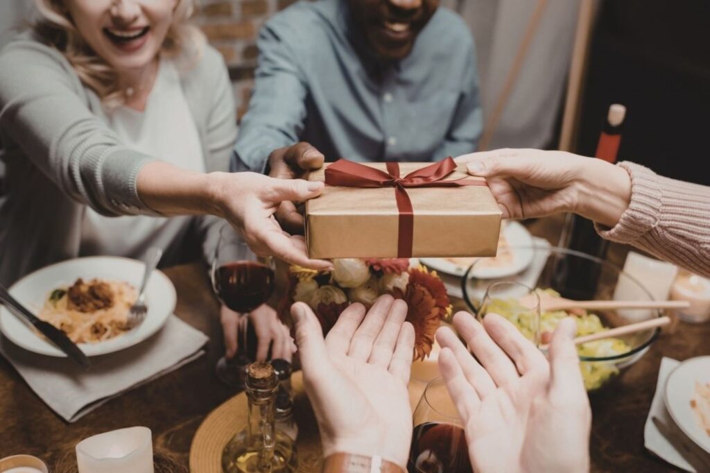 Europees gezin wisselt vrolijk kerstcadeaus uit in een gezellige woonkamer, wat stressvermindering tijdens de feestdagen aantoont door zinvolle verbindingen, vereenvoudigde vieringen en focus op quality time boven perfectionisme tijdens de feestperiode