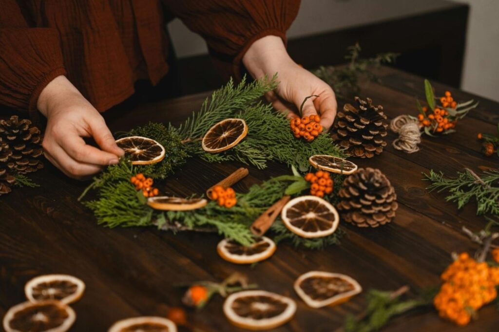 Handmade natural Christmas decorations using pinecones, dried orange slices, and cinnamon for zero-waste celebrations, representing sustainable European holiday decor eliminating plastic ornaments and disposable materials