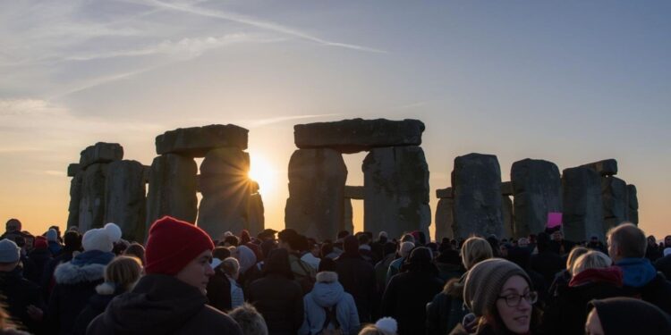 Thousands gathering at Stonehenge for winter solstice sunrise celebrations on December 21, representing ancient European feast traditions honoring shortest day and longest night of year