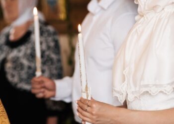 Traditional Lucia Day festival procession with girl wearing white gown and candle crown leading attendants through Swedish church, representing Scandinavia's beloved December 13 light celebration