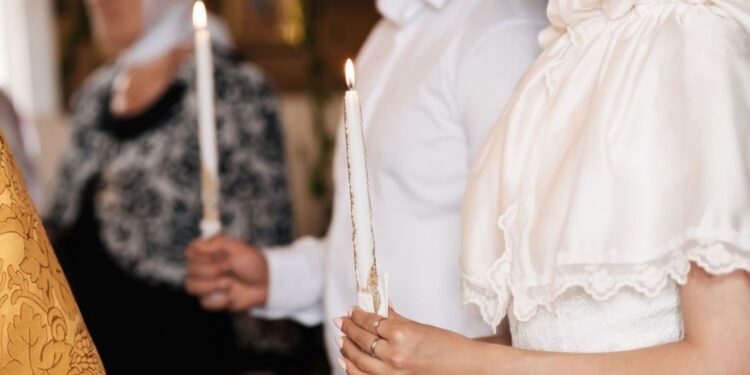 Traditional Lucia Day festival procession with girl wearing white gown and candle crown leading attendants through Swedish church, representing Scandinavia's beloved December 13 light celebration