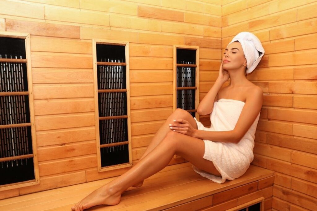 Person relaxing in infrared sauna wellness spa for cellular health recovery representing European wellness trends 2026 prioritizing therapeutic heat technology and preventative health care