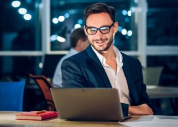 Bootstrap startup founder working on laptop in European cafe building profitable business