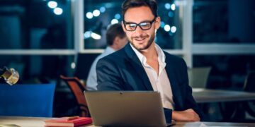 Bootstrap startup founder working on laptop in European cafe building profitable business