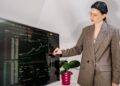 A businesswoman reviews a map of EU cohesion funds allocation by region in a modern office