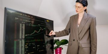 A businesswoman reviews a map of EU cohesion funds allocation by region in a modern office