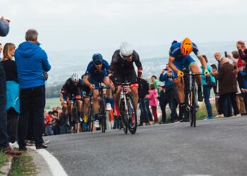 A cyclist pushes through a mountain stage crowd during one of the most iconic open-air sporting events in Europe