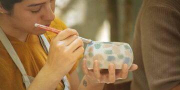 Eine Kunsthandwerkerin bemalt Porzellan in einer der gefeiertsten EU-geschützten Handwerksregionen Europas