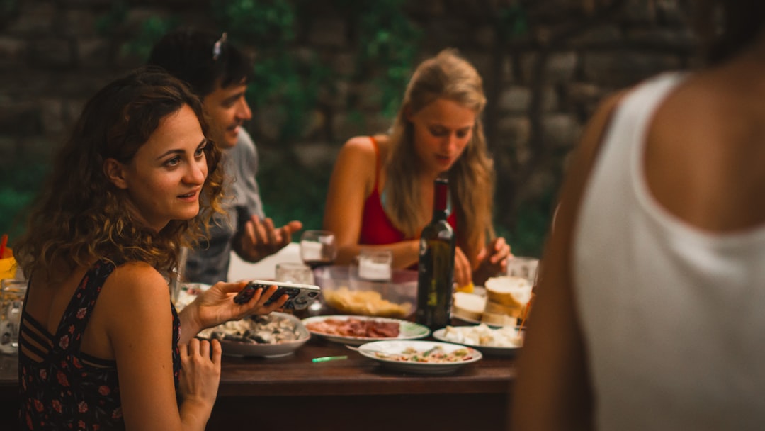 A group of friends share an outdoor dinner under the long hours of June daylight, celebrating Nordic midsummer with ease and warmth.
