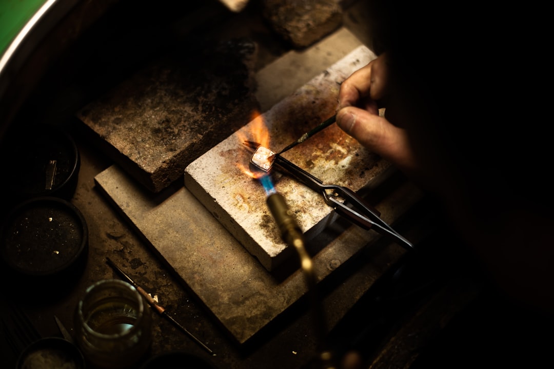 A jeweller weaving fine silver threads in a heritage studio representative of EU-protected craft regions across Portugal