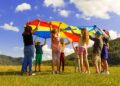 A group of children attending EU summer camps, sitting outdoors and practicing language activities together