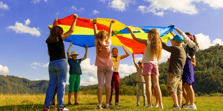 Un grupo de niños asistiendo a campamentos de verano de la UE, sentados al aire libre y practicando actividades de idiomas juntos