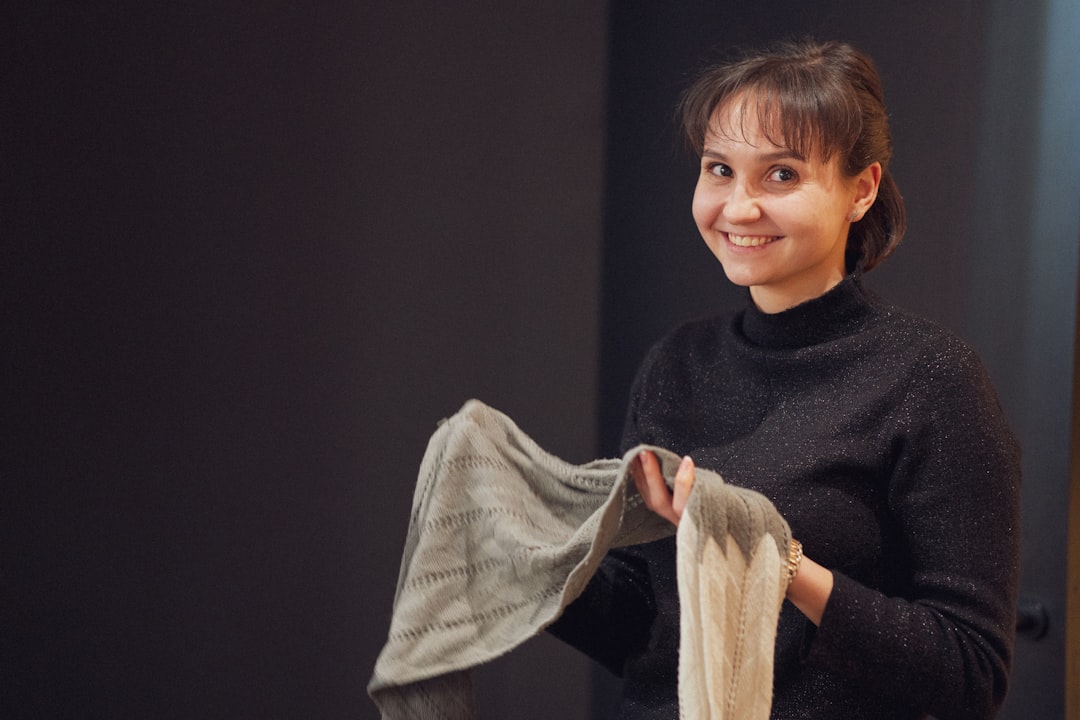 Eine modebewusste Frau inspiziert zertifizierte nachhaltige Stoffe und sucht nach echten EU-Ecolabel-Zertifizierungszeichen