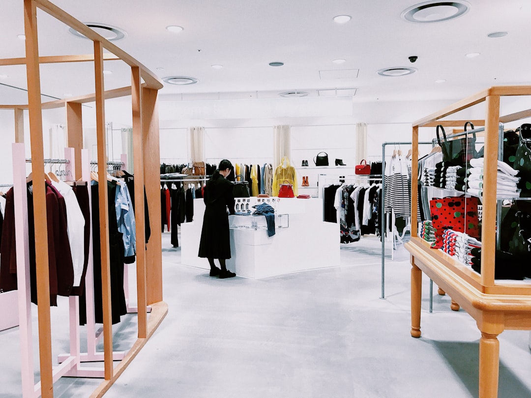 A woman browsing a curated selection of linen brands in a sustainable European fashion boutique during summer