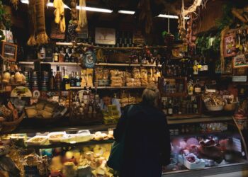 A woman tasting Parmigiano Reggiano in a traditional Italian caseificio, a celebrated EU geographical indication food.