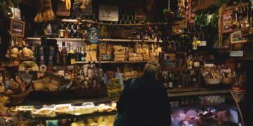 A woman tasting Parmigiano Reggiano in a traditional Italian caseificio, a celebrated EU geographical indication food.