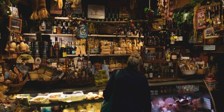 woman-tasting-aged-cheese-italy-unsplash - EUwebzine Een vrouw die Parmigiano Reggiano proeft in een traditionele Italiaanse caseificio, een beroemde EU-voedingsmiddel met geografische aanduiding.