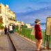 A woman strolls through a sunlit alley in one of the most charming EU beach towns in late June