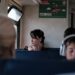 A woman reading in a private cabin aboard overnight trains across Europe, soft evening light through the window