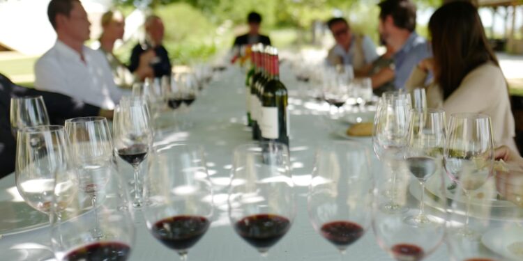 A sommelier guides a guest through a private tasting inside a historic EU vineyard cellar in Burgundy, France