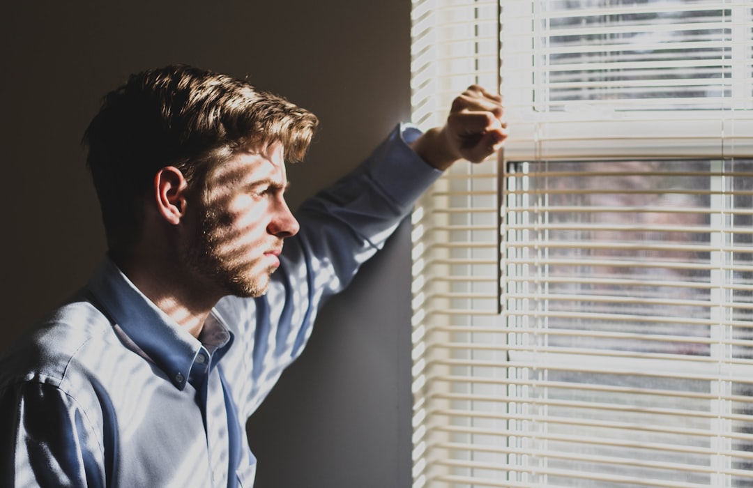 A person closing window shutters at home, a key cooling habit to stay healthy during a heatwave