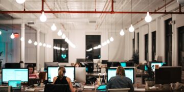 A startup founder researching EU funding programmes on a laptop in a modern office