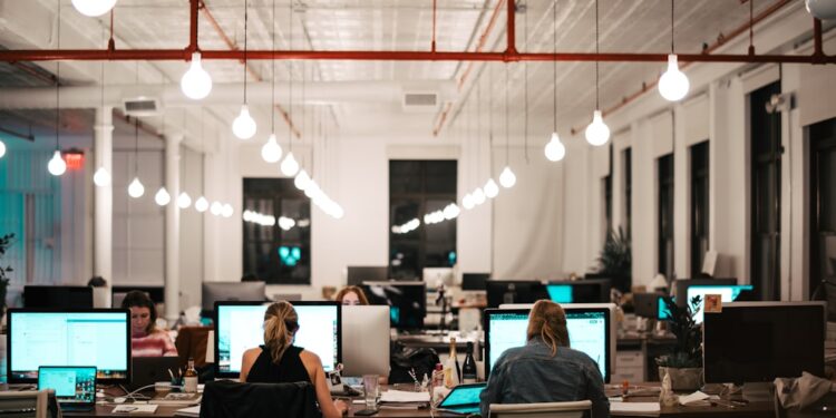 A startup founder researching EU funding programmes on a laptop in a modern office