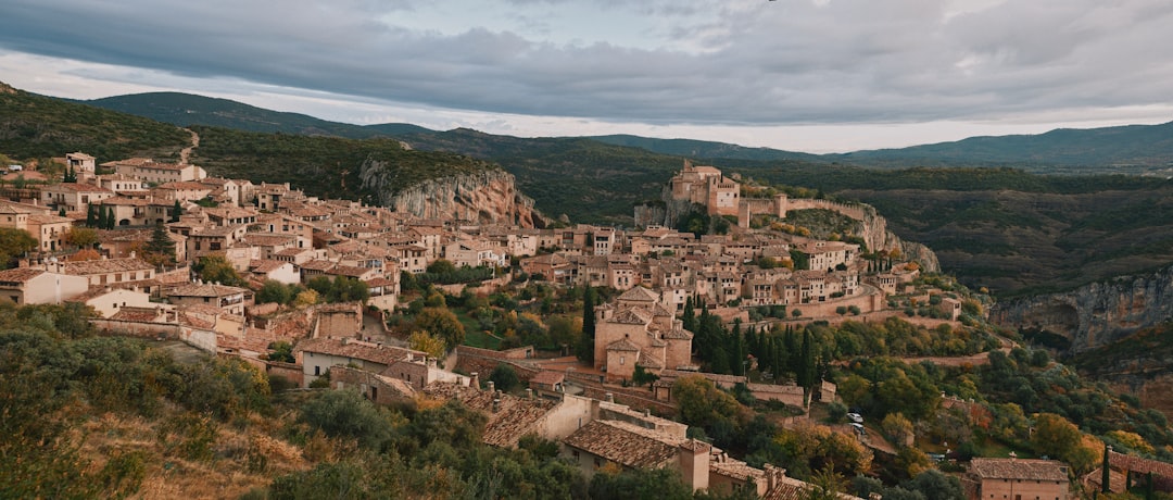 A traveller in light summer clothing explores the heritage streets of an EU mountain village.