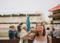 A woman carefully reading allergen free product labels at a vibrant European summer festival market stall