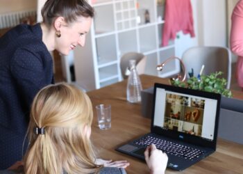 Una fondatrice donna esamina i dati di conformità del commercio elettronico transfrontaliero sul suo laptop in un luminoso ufficio europeo