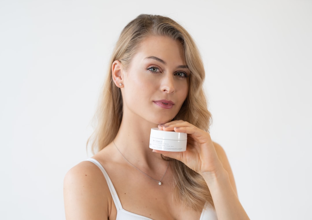 A woman reading the ingredient label on a moisturiser formulated with regulated EU skincare actives
