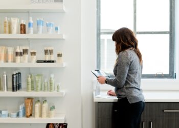 A woman carefully examines a product label in a pharmacy, reflecting the transparency promised by EU cosmetic standards.