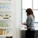 woman-reading-skincare-label-store-unsplash - EUwebzine A woman carefully examines a product label in a pharmacy, reflecting the transparency promised by EU cosmetic standards.