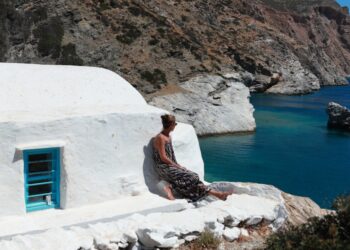 A woman arriving by boat at a private island in the Greek Aegean, embodying the seclusion of EU private island rentals
