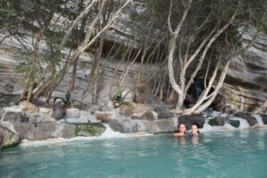 A woman relaxing in a certified thermal spa pool surrounded by historic stone architecture in Europe