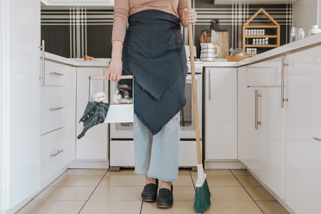 A woman using an EU Ecolabel certified cleaning product while wiping down her kitchen counter at home.