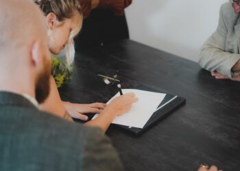 Two professionals reviewing a cross-border EU supplier contract at a modern office desk, discussing key clauses.