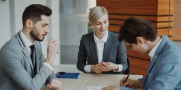 businesswoman-reviewing-legal-documents-office-unsplash - EUwebzine A procurement manager reviewing EU supplier contracts at her office desk before the autumn trading season
