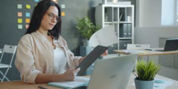 businesswoman-reviewing-supply-chain-documents-unsplash - EUwebzine A sustainability officer reviews supply chain audit documents to prepare for EU Deforestation Regulation compliance.